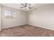 Carpeted bedroom featuring a bright window for natural light and a ceiling fan at 2602 E Glass Ln, Phoenix, AZ 85042