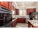 Updated kitchen featuring cherry cabinets, stainless steel appliances, granite countertops, and gas stovetop at 2602 E Glass Ln, Phoenix, AZ 85042