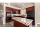 Updated kitchen featuring granite countertops, cherry cabinets, stainless steel appliances, and an island at 2602 E Glass Ln, Phoenix, AZ 85042