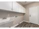The laundry room has plenty of storage cabinets, a sink, and wood-look flooring at 2602 E Glass Ln, Phoenix, AZ 85042