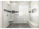 Modern shower with pebble flooring, a built in bench, and a unique window for natural light at 2602 E Glass Ln, Phoenix, AZ 85042