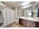 Well-lit bathroom featuring a single vanity, toilet, and shower with a shower curtain for privacy at 2716 W Sunland Ave, Phoenix, AZ 85041