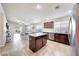 Open-concept kitchen with a center island, dark cabinetry, and stainless steel appliances at 2716 W Sunland Ave, Phoenix, AZ 85041