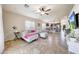 Open-concept living room with tile flooring and a ceiling fan, seamlessly flowing into the dining and kitchen areas at 2716 W Sunland Ave, Phoenix, AZ 85041