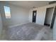 Minimalist bedroom with window, neutral walls, and doorway leading to the ensuite bathroom at 2988 E Mecklenburg Way, San Tan Valley, AZ 85143