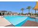 Resort-style community pool featuring palm trees, sunshades, lounge chairs, and a water park at 2988 E Mecklenburg Way, San Tan Valley, AZ 85143