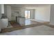 Bright, open-concept living area with kitchen island, tile flooring, and sliding glass door to patio at 2988 E Mecklenburg Way, San Tan Valley, AZ 85143