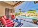 Covered patio area with red cushioned seating overlooking a pool and rock waterfall at 3214 N 138Th Dr, Avondale, AZ 85392