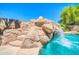 The backyard features a rock waterfall cascading into the pool at 3214 N 138Th Dr, Avondale, AZ 85392