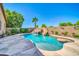 Backyard pool featuring a rock waterfall, slide, and a swim-up bar, surrounded by desert landscaping at 3214 N 138Th Dr, Avondale, AZ 85392