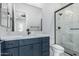 Bathroom features an undermount sink in a blue vanity, and a glass-enclosed shower with decorative tile at 3653 E Runaway Bay Pl, Queen Creek, AZ 85142