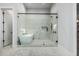 Modern bathroom featuring marble floors, glass shower, and contemporary soaker tub at 3653 E Runaway Bay Pl, Queen Creek, AZ 85142