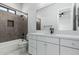 Modern bathroom with tub, decorative tile, white cabinets, and black hardware at 3653 E Runaway Bay Pl, Queen Creek, AZ 85142