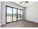 Bedroom showcases hardwood flooring, ceiling fan, and glass sliding doors offering outdoor views at 3653 E Runaway Bay Pl, Queen Creek, AZ 85142
