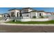 Beautiful modern home with crisp white exterior, synthetic turf landscaping, decorative rocks, and dark trim at 3653 E Runaway Bay Pl, Queen Creek, AZ 85142