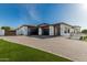 Contemporary home featuring a three-car garage, textured driveway, and well-maintained synthetic turf landscaping at 3653 E Runaway Bay Pl, Queen Creek, AZ 85142