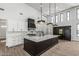 Modern kitchen featuring an island, marble countertops, custom cabinets, and stainless steel appliances at 3653 E Runaway Bay Pl, Queen Creek, AZ 85142