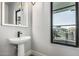 Bright powder room features a modern vanity, decorative mirror, and window to the exterior at 3653 E Runaway Bay Pl, Queen Creek, AZ 85142