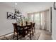 Elegant dining room featuring a wooden table, leather chairs, and stylish wall art at 37790 W Santa Clara Ave, Maricopa, AZ 85138
