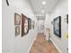 Long, well-lit hallway featuring decorative Gathering photos and tiled flooring leading to other rooms at 3801 N Goldwater Blvd # 201, Scottsdale, AZ 85251