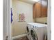 Well-equipped laundry room featuring a washer, dryer, storage cabinets and delightful Hershey's Chocolate Factory poster at 3801 N Goldwater Blvd # 201, Scottsdale, AZ 85251