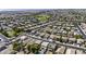 Expansive aerial view of a neighborhood with numerous homes, green spaces, and a pond, showcasing the community's layout and environment at 41839 W Avella Dr, Maricopa, AZ 85138