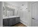 Well-lit bathroom with double sinks, gray vanity, and a shower-tub combo, for a functional space at 41839 W Avella Dr, Maricopa, AZ 85138