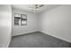 Well-lit bedroom showcasing a large window with neutral carpet and white walls at 41839 W Avella Dr, Maricopa, AZ 85138