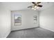 Bedroom with neutral carpet, white walls, ceiling fan and two windows providing natural light at 41839 W Avella Dr, Maricopa, AZ 85138