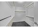 Walk-in closet with wooden rods and shelves, offering ample storage space and a clean, minimalist design for organizing clothes at 41839 W Avella Dr, Maricopa, AZ 85138