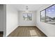 Bright dining room featuring wood flooring, white walls, and large windows showcasing the neighborhood views at 41839 W Avella Dr, Maricopa, AZ 85138