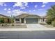 Charming single-story home with a two-car garage, desert landscaping, and tile roof under a bright sky at 41839 W Avella Dr, Maricopa, AZ 85138