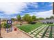 Lush backyard featuring artificial turf, decorative pavers, and well-maintained landscaping at 4216 W Harwell Rd, Laveen, AZ 85339
