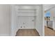 Bright laundry closet featuring white shelving, wood-look floors, and washer/dryer hookups for convenience at 4720 W Northview Ave, Glendale, AZ 85301