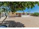 Well-maintained backyard with gravel landscaping and a mature shade tree at 6051 E Ensenada St, Mesa, AZ 85205