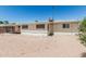 Back exterior view features neutral paint, simple landscaping, and updated windows at 6051 E Ensenada St, Mesa, AZ 85205