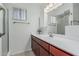 Bathroom features a vanity with wood cabinets and white countertops, mirror and updated lighting at 6051 E Ensenada St, Mesa, AZ 85205