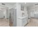 Bright kitchen features stainless steel refrigerator, white cabinets and counters, with open access to living areas at 6051 E Ensenada St, Mesa, AZ 85205