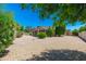 Mature landscaping and gravel cover accent the large backyard and covered patio at 6180 W Oraibi Dr, Glendale, AZ 85308