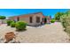 Backyard view of stucco house with a covered patio and gravel landscaping at 6180 W Oraibi Dr, Glendale, AZ 85308