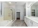 Bright bathroom with double vanity, soaking tub, and glass enclosed shower at 6180 W Oraibi Dr, Glendale, AZ 85308