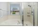 Bathroom featuring soaking tub, glass shower, and window at 6180 W Oraibi Dr, Glendale, AZ 85308