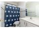 Bathroom featuring shower with blue flower curtain and white sink vanity at 6180 W Oraibi Dr, Glendale, AZ 85308