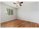 Bright bedroom with wood floors, ceiling fan, and large window with shutters at 6180 W Oraibi Dr, Glendale, AZ 85308