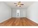 Open bedroom with hardwood floors, ceiling fan and view to the hallway at 6180 W Oraibi Dr, Glendale, AZ 85308