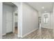 Inviting hallway with wood-style floors, white trim, and neutral paint at 6180 W Oraibi Dr, Glendale, AZ 85308