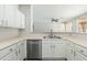 Bright kitchen featuring stainless steel dishwasher, double sink, and white cabinetry at 6180 W Oraibi Dr, Glendale, AZ 85308