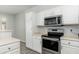 Modern kitchen features stainless steel range, microwave, and white cabinets at 6180 W Oraibi Dr, Glendale, AZ 85308
