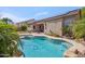 A refreshing pool is in the landscaped backyard with a covered patio and a house with solar panels at 6827 W El Cortez Pl, Peoria, AZ 85383