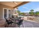 Covered patio with outdoor table and seating overlooking backyard pool and landscaping at 6827 W El Cortez Pl, Peoria, AZ 85383